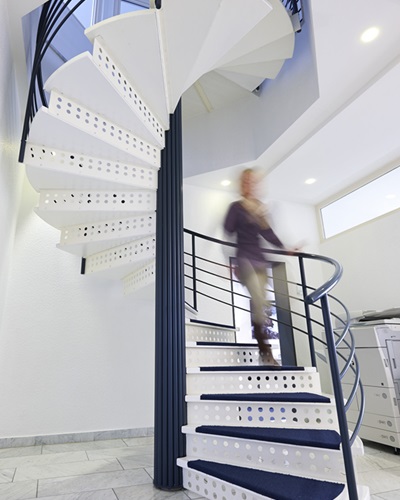 Eine Mitarbeiterin der Steuerkanzlei Wolvers und Neuy kommt die Wendeltreppe herunter